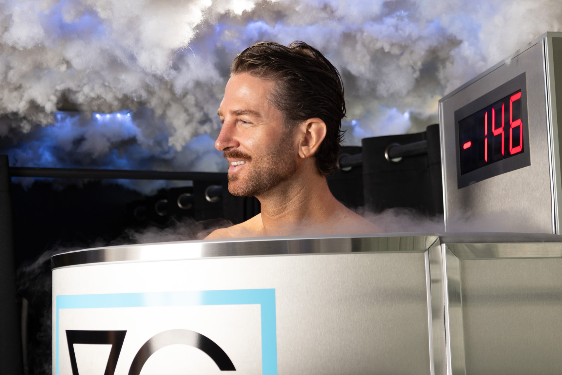 Client smiling inside the cryotherapy chamber